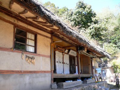 韓国の昔からの家。竹葺きの屋根に黄土の壁。家訓が外に飾ってあります。